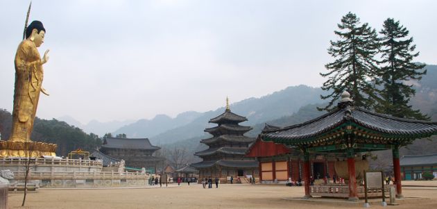 The Beopjusa Buddhist Temple with ancient buildings including a bell pavilion, a large pagoda pavilion, and a large golden Buddha statue.