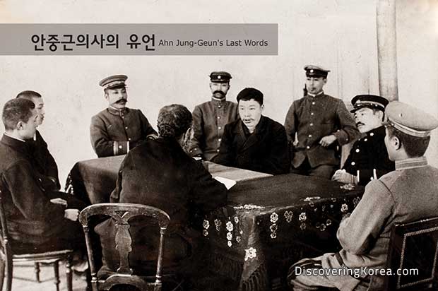 An old sepia photo of Ahn Jun-Geun addressing army officers around a table with a dark cloth.