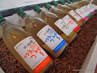 Bottles of rice beer lying next to each other on wooden pellets, close up.