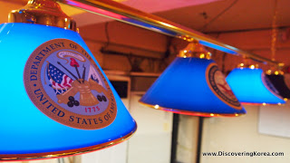 Close up of blue lampshades with United States emblems on them, lit up.