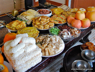 A table laden with a feast for Seollal, there are pancakes, sweet treats, apples, and noodle dishes.