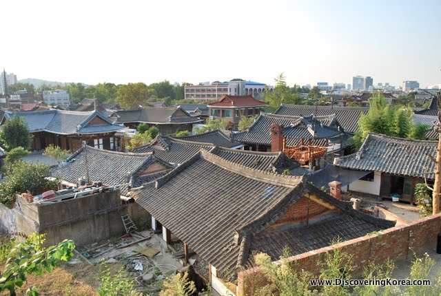 View over the roofs of Jeonju, the dark tile, traditional curved rooftops contrast from the modern buildings in the background.