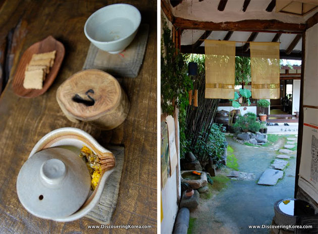 A tea house in Jeonju. On the left is a pot of tea on a wooden surface, on the right is a view into a courtyard with paving stones.